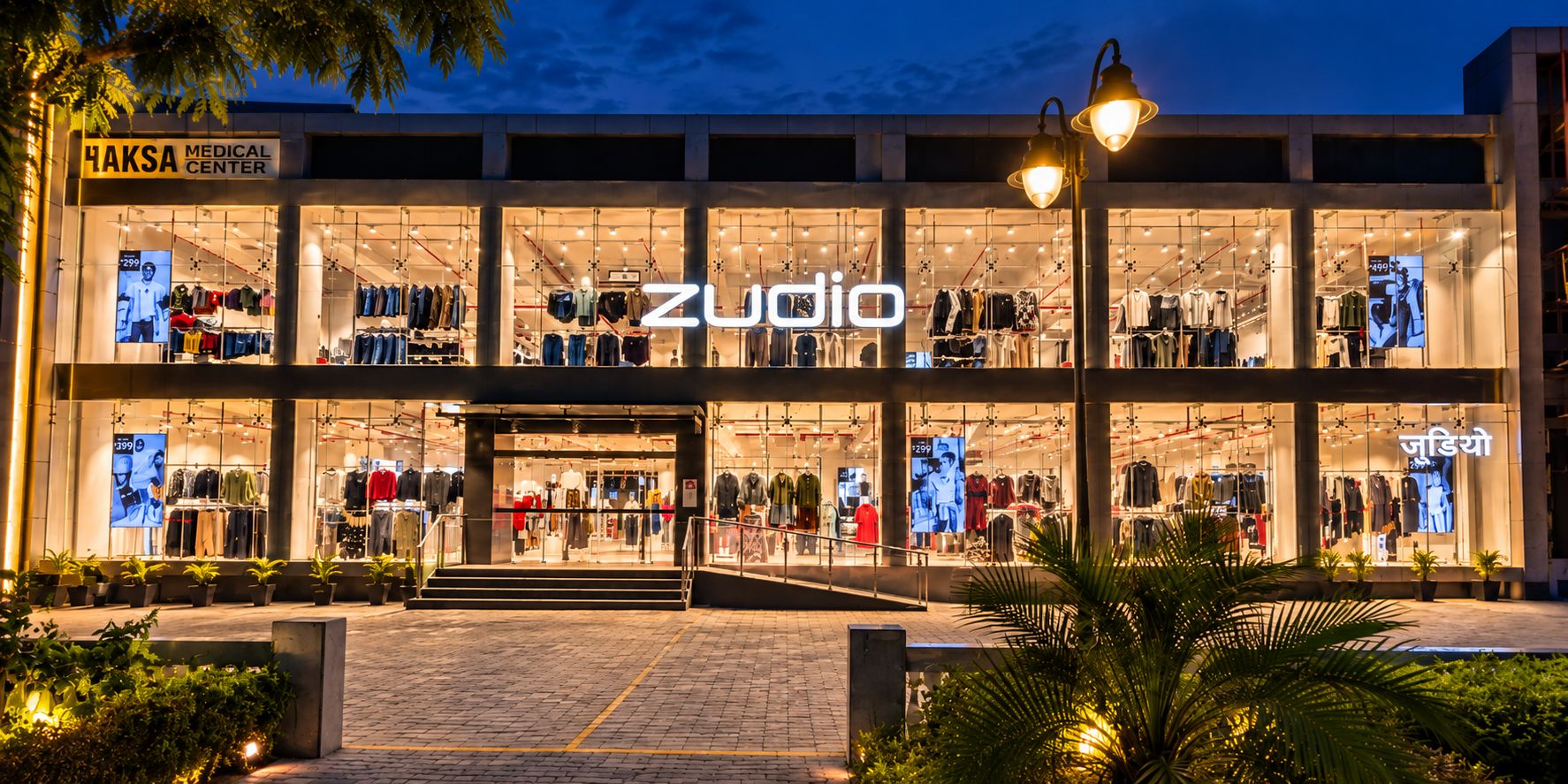 Zudio storefront lit up at dusk